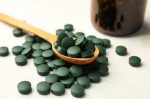 bottle-wooden-spoon-with-spirulina-pills-white-textured-background_185193-28597