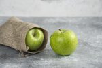 Delicious green apples out of burlap on marble background. High quality photo